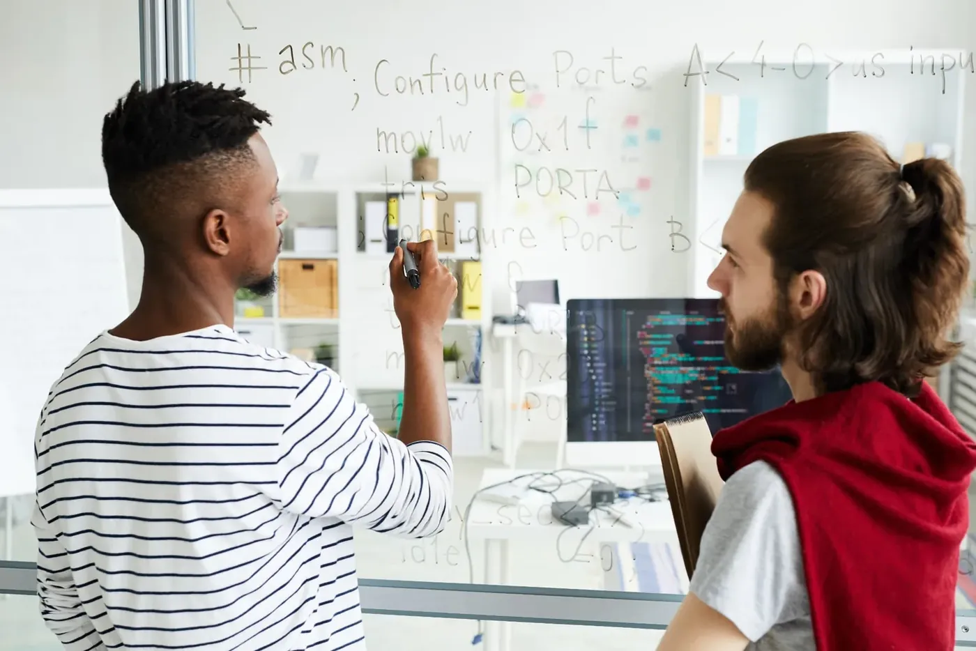 Developers working through code on a glass board, an information and computing sciences R&D project